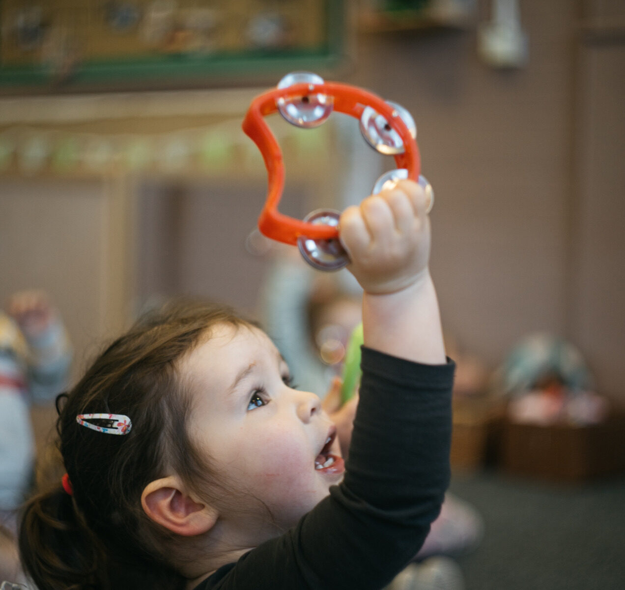Small Child Holding Musical Bell Shaker