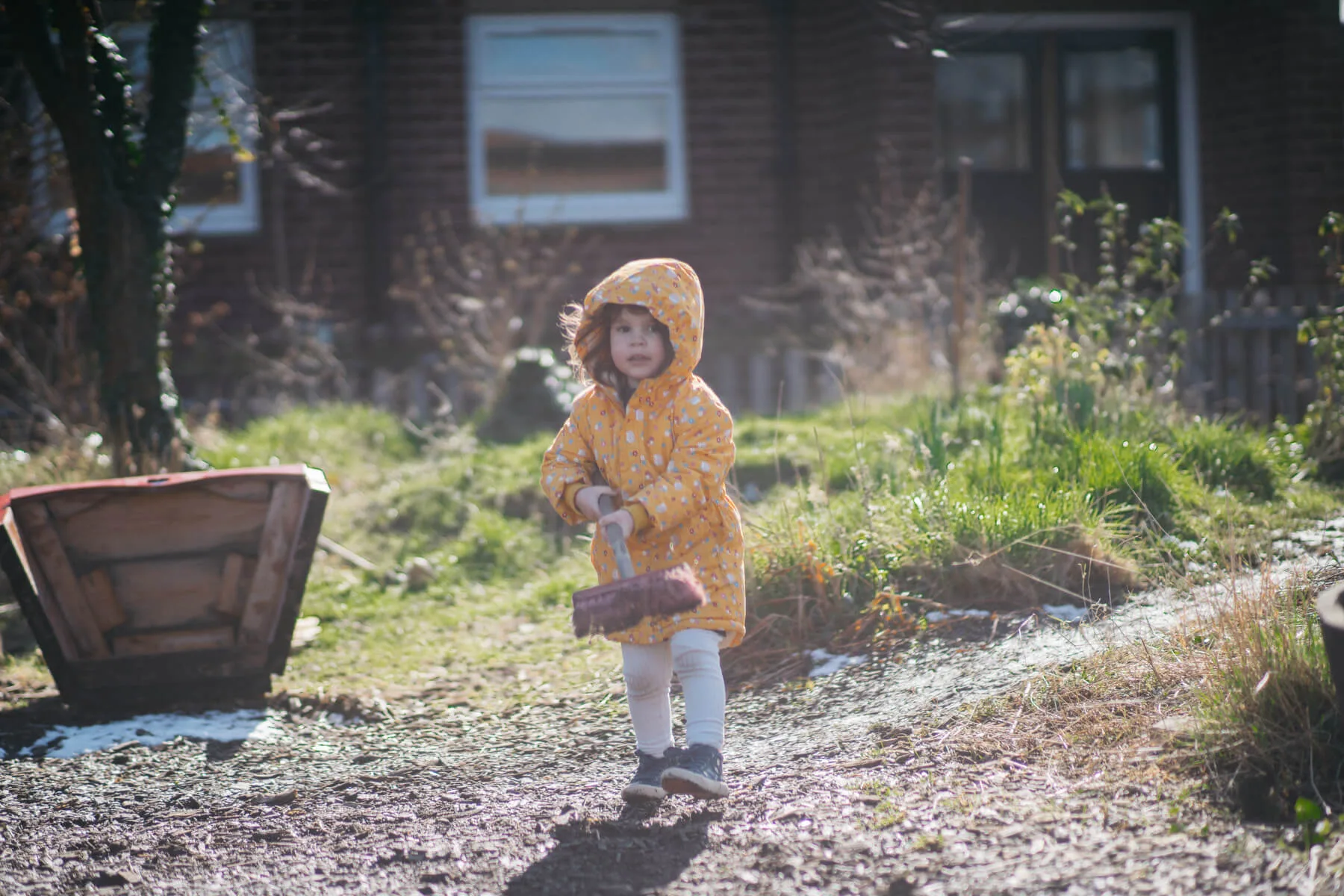 Child Playing in Garden With Broom