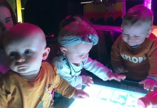 Three Small Children Playing With Touchscreen